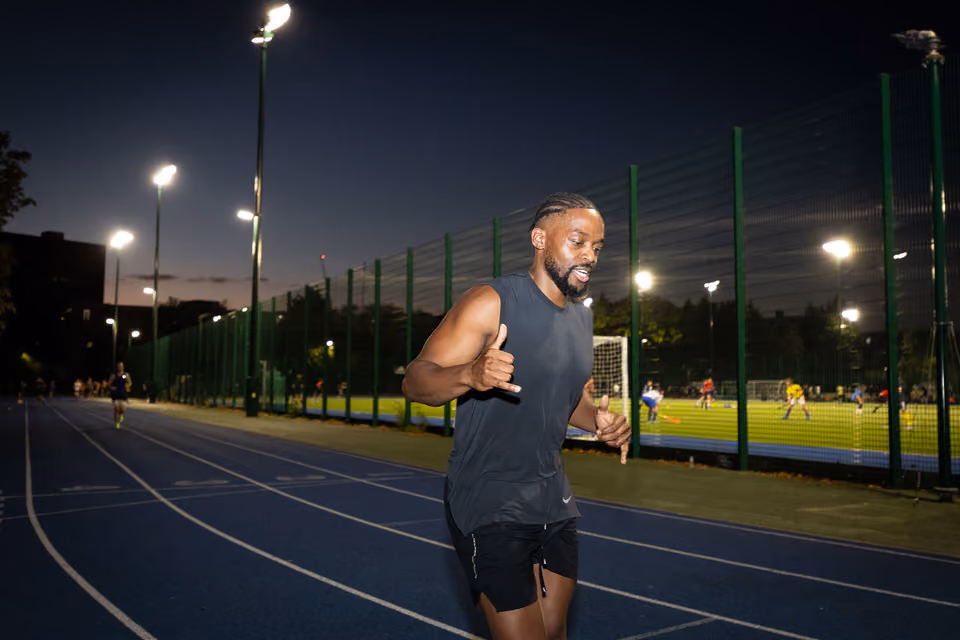 MXO coach leading an outdoor running session at dusk